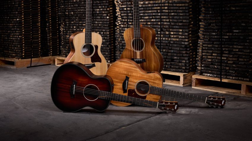 Four Taylor GS Mini acoustic guitars in a group with two standing vertically and two laying horizontally